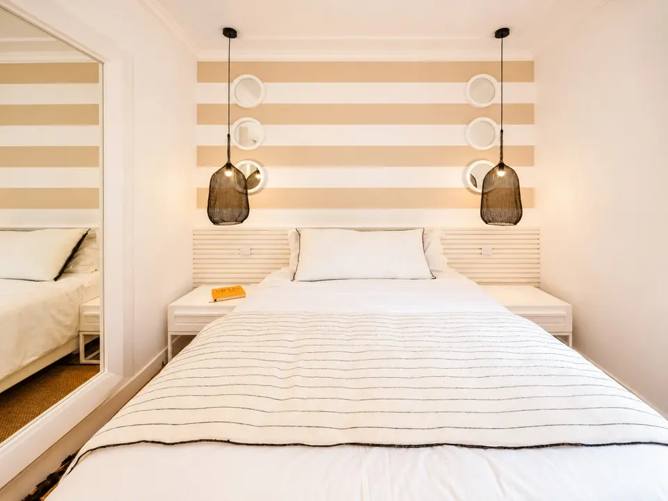 Cama com iluminação suspensa no segundo quarto